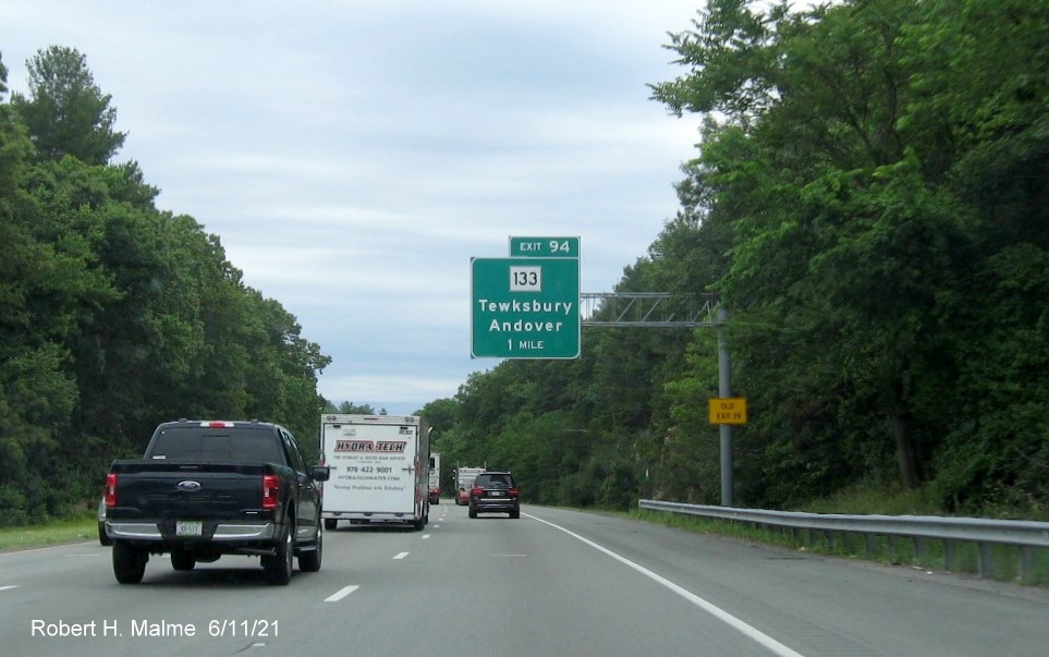 Image of 1 mile advance overhead sign for MA 133 exit with new milepost based exit number and yellow Old Exit 39 sign on support on I-495 North in Tewksbury, June 2021