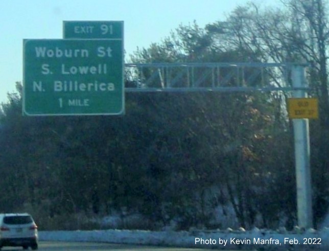 Image of recently placed 1 mile advance overhead sign for Woburn Street exit with transferred Old Exit 33 sign on support on I-495 North in Lowell, by Kevin Manfra, February 2022