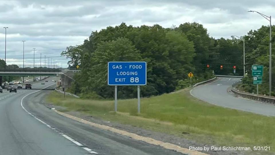 Image of blue services sign for MA 110 exit with new milepost based exit number on I-495 North in Chelmsford, by Paul Schlichtman, May 2021