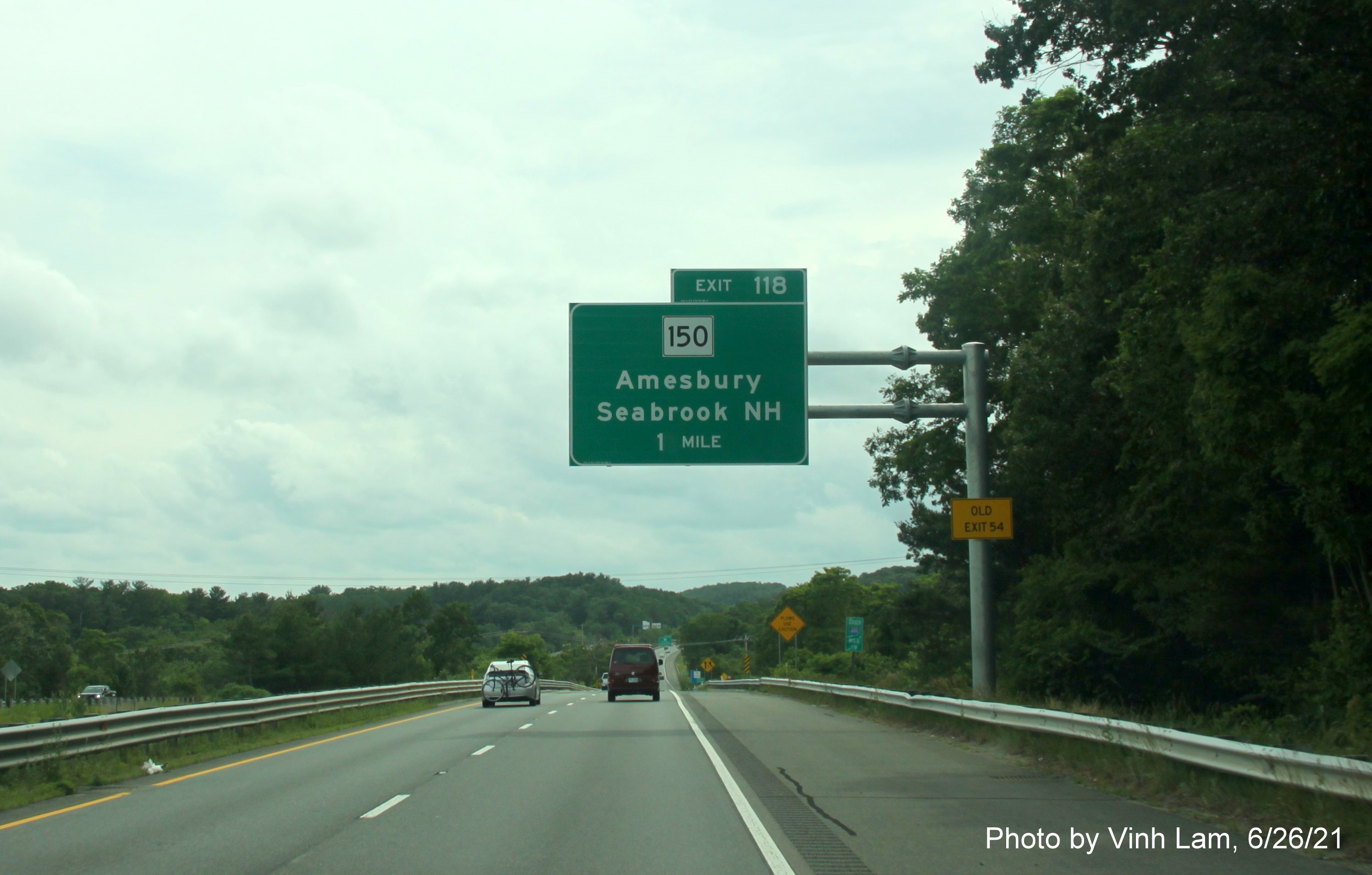 Image of 1 mile advance overhead sign for MA 150 exit with new milepost based exit number and yellow Old Exit 54 sign on support on I-495 South in Amesbury, photo bt Vinh Lam, June 2021