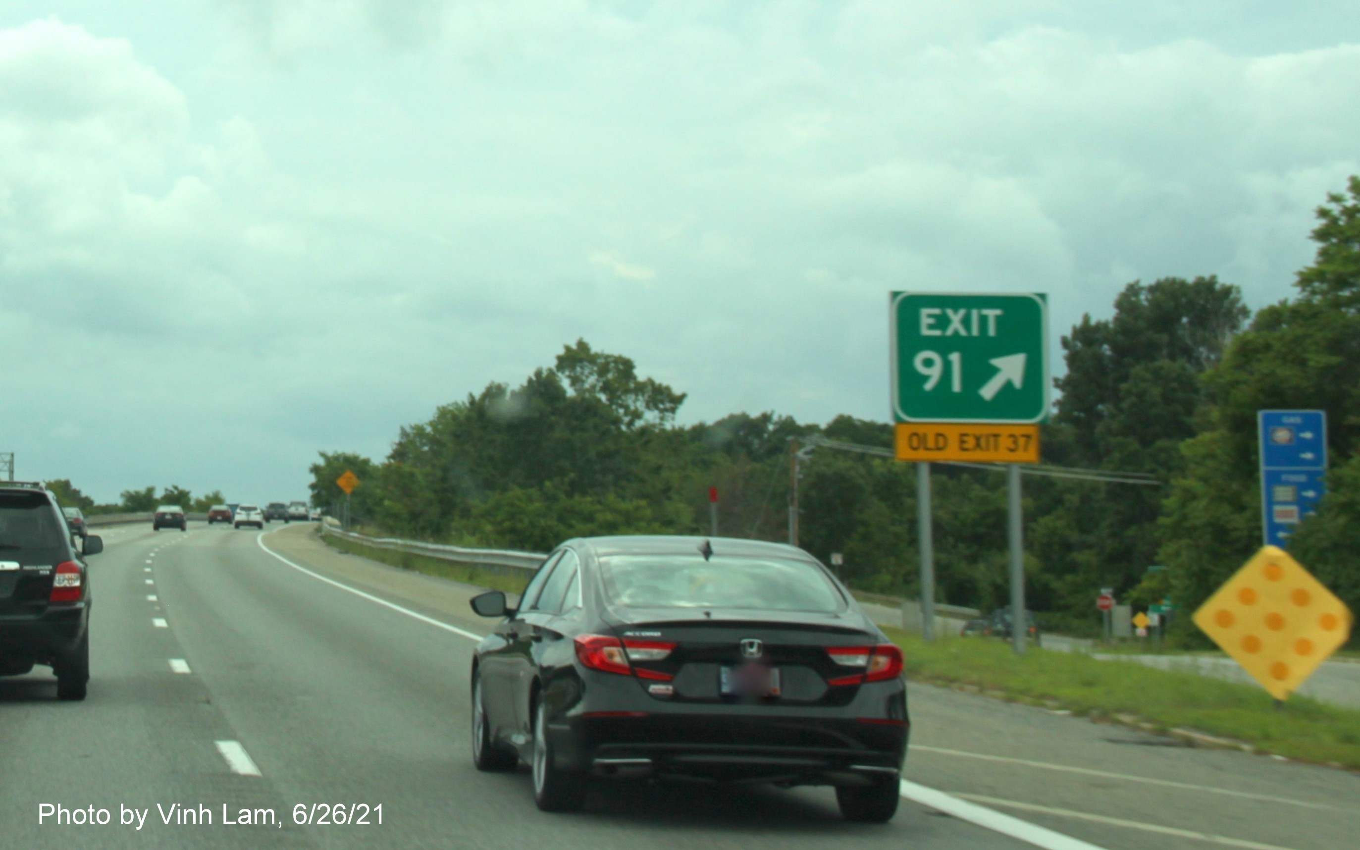 Image of gore sign for Woburn Street exit with new milepost based exit number and yellow Old Exit 37 sign attached below on I-495 South in Lowell, by Vinh Lam, June 2021