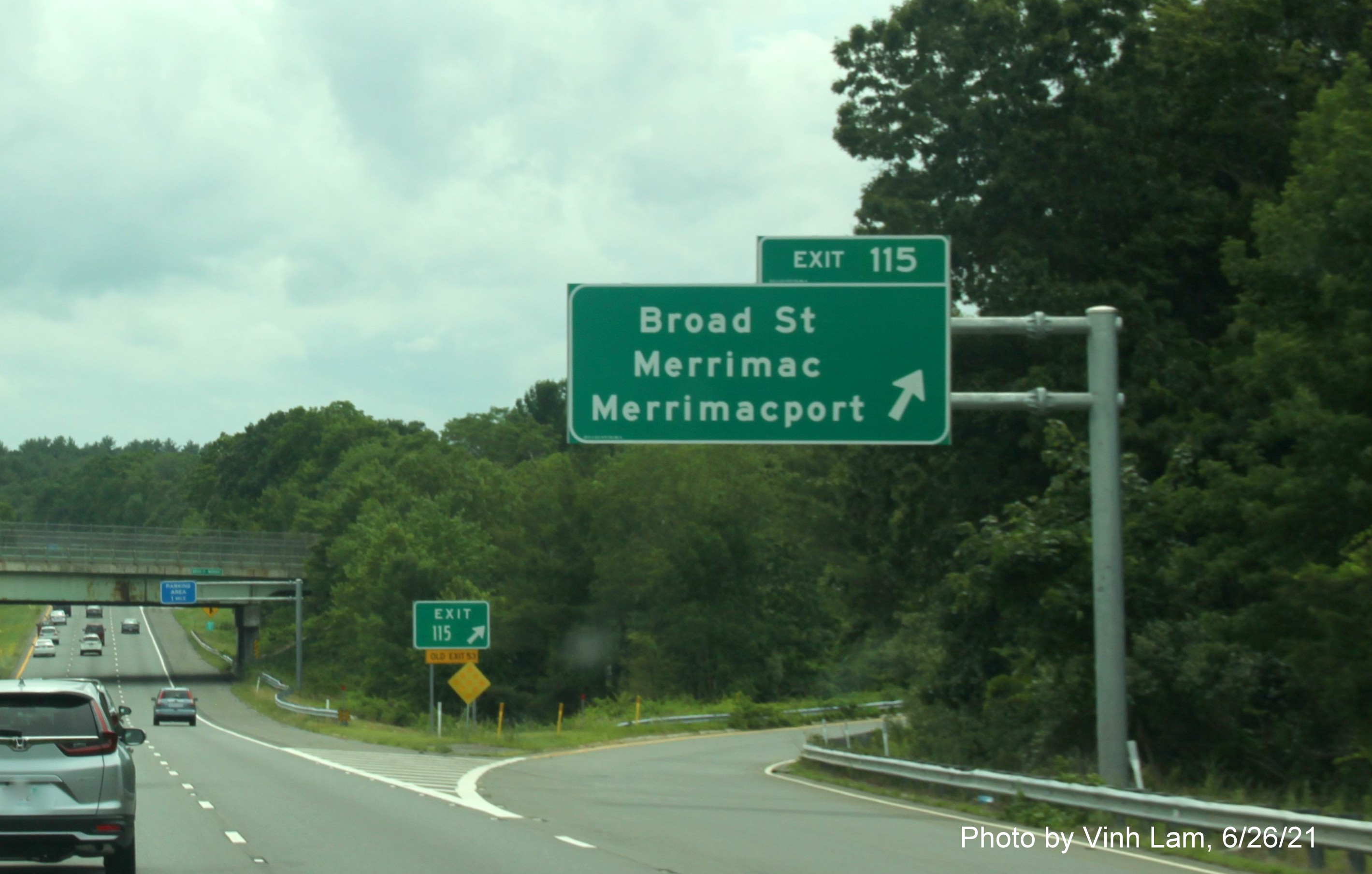 Image of overhead ramp sign for Broad Street exit with new milepost based exit number and yellow Old Exit 53 advisory sign on support on I-495 South in Amesbury, photo by Vinh Lam, June 2021