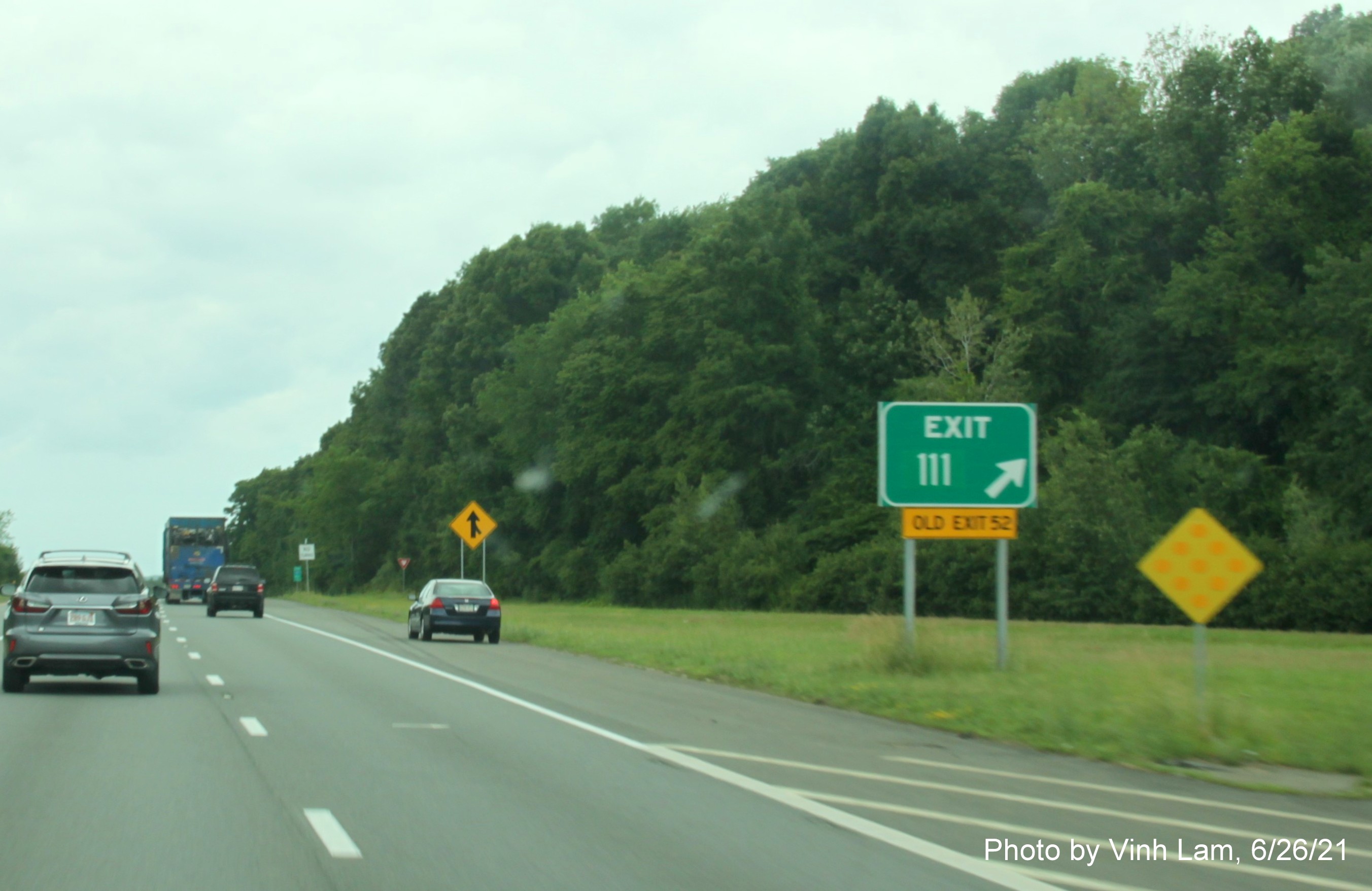 Image of gore sign for MA 110 exit with new milepost based exit number and yellow Old Exit 52 advisory sign attached below on I-495 South in Haverhill, photo by Vinh Lam, June 2021