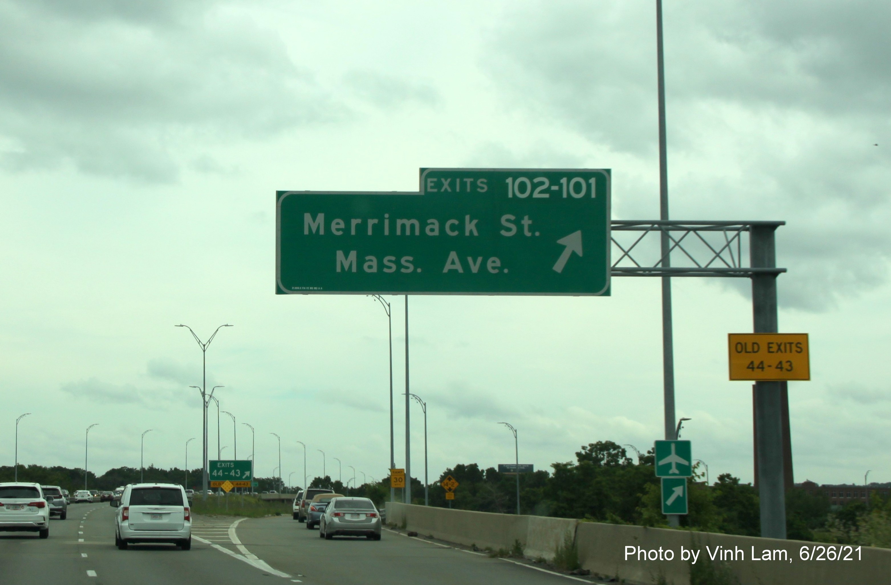 Image of overhead ramp signs for Merrimack Street and Mass. Avenue exits with new milepost based exit number and yellow Old Exits 44-43 advisory sign on support on I-495 South in Lawrence, by Vinh Lam, June 2021