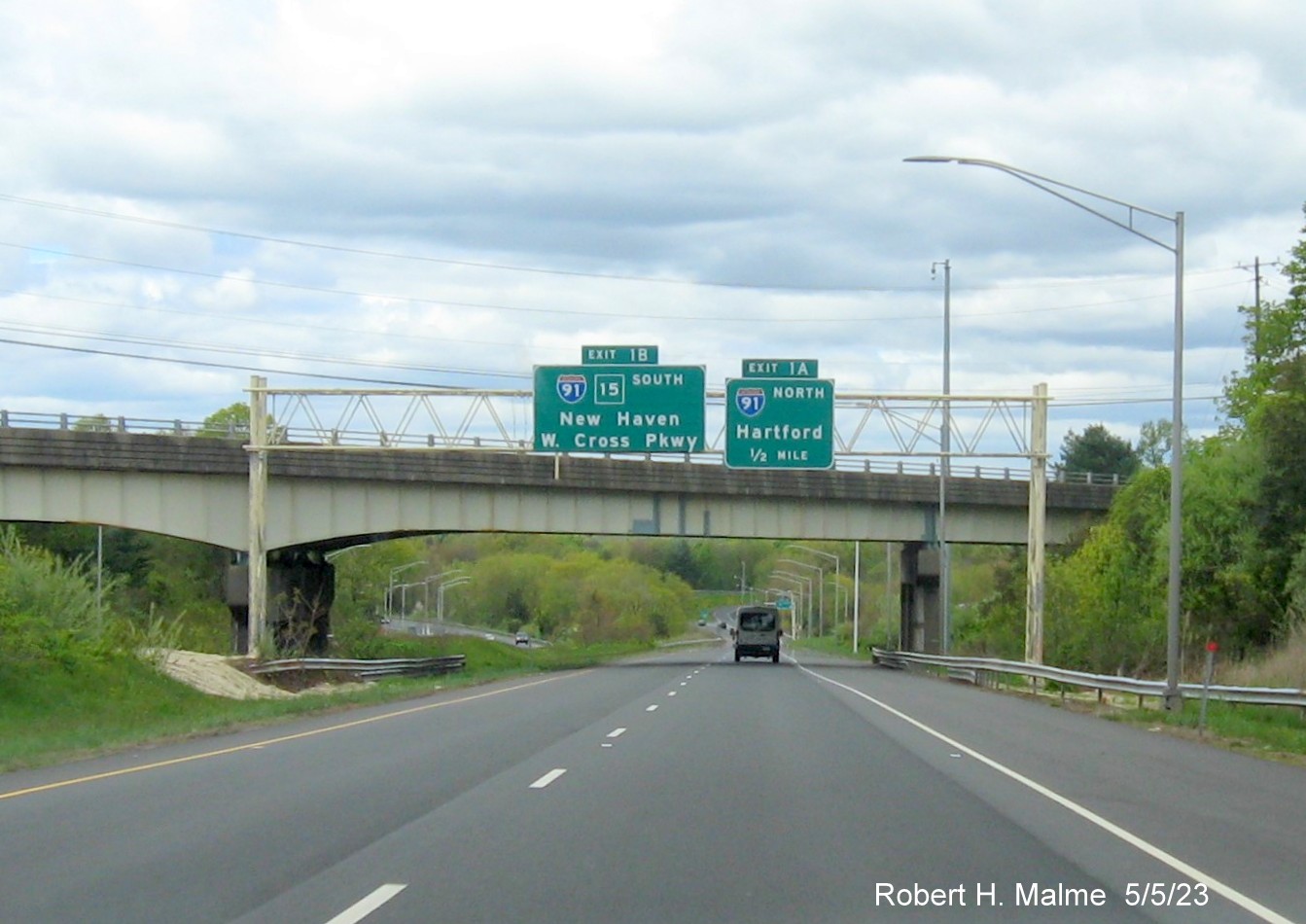 Image of overhead advance signs for I-91 exits with new milepost based exit numbers at beginning of I-691 in Meriden CT, May 2023