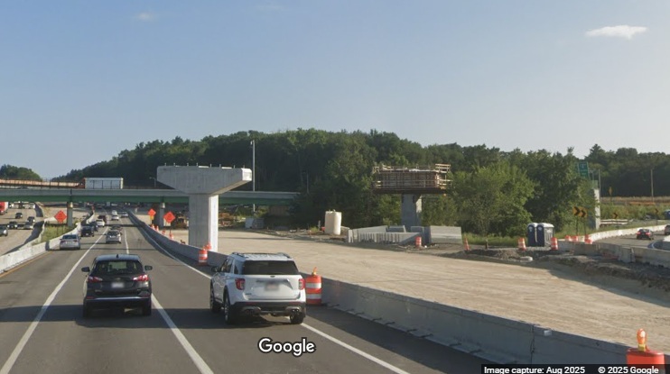 Image of supports being constructed for future flyover ramp from I-90 East to I-495 North 
	as part of new I-90/Mass Pike interchange construction in Hopkinton, Google Maps Street View, August 2025