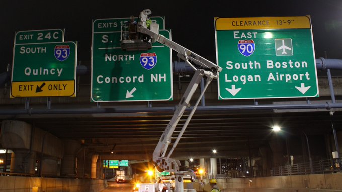 MassDOT image of workers changing I-90/Mass Pike exit numbers at the I-93 exit in Boston, January 2021