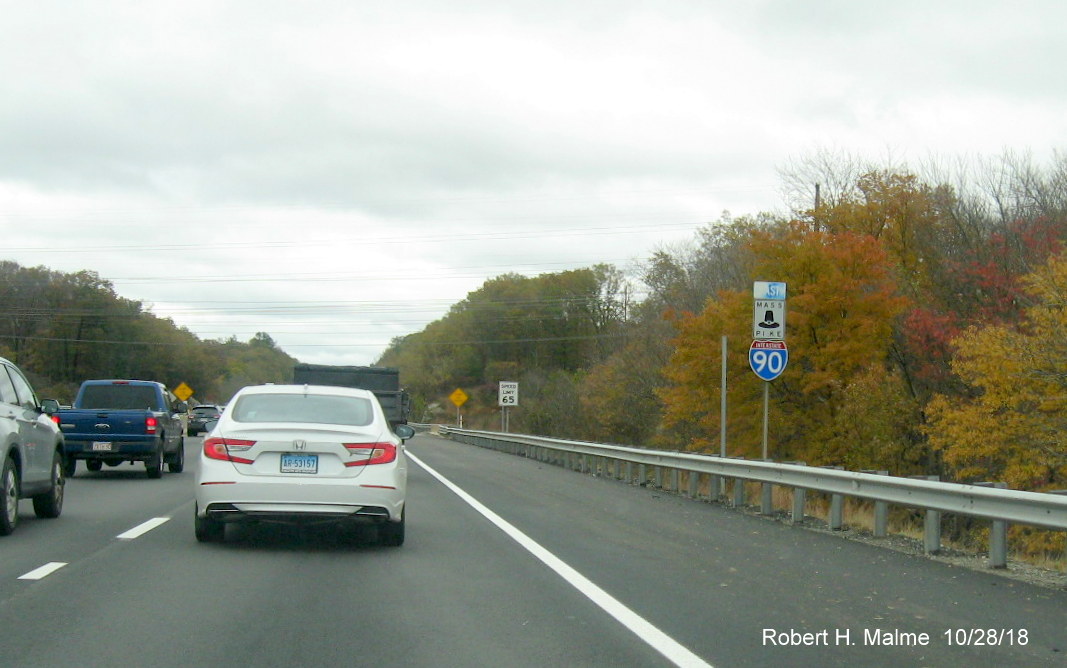Image of EAst I-90/Mass Pike reassurance marker and speed limit sign with posts for new signs behind them in Millbury