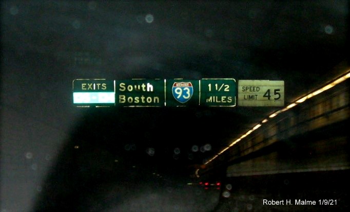 Image of 1 1/2 mile advance sign for I-93 and South Boston Exits mounted to roof of Ted Williams Tunnel with new milepost based exit numbers, January 2021