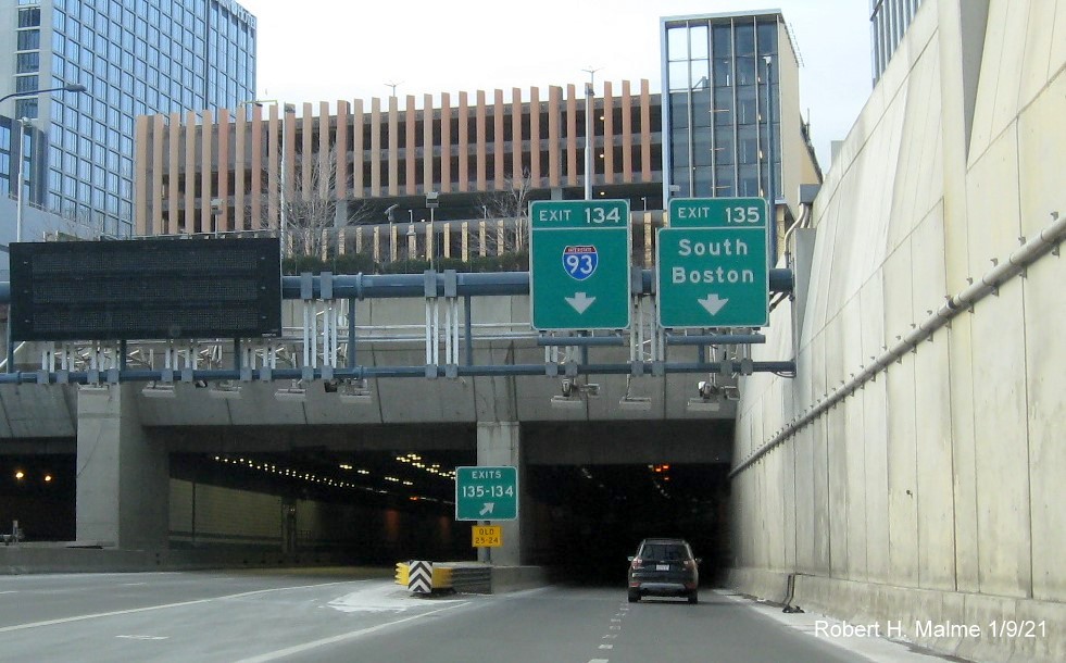 Image of overhead ramp sign for I-93 and South Boston Exits with new milepost based exit number and gore sign
                                       with yellow Old exit numbers sign below, January 2021