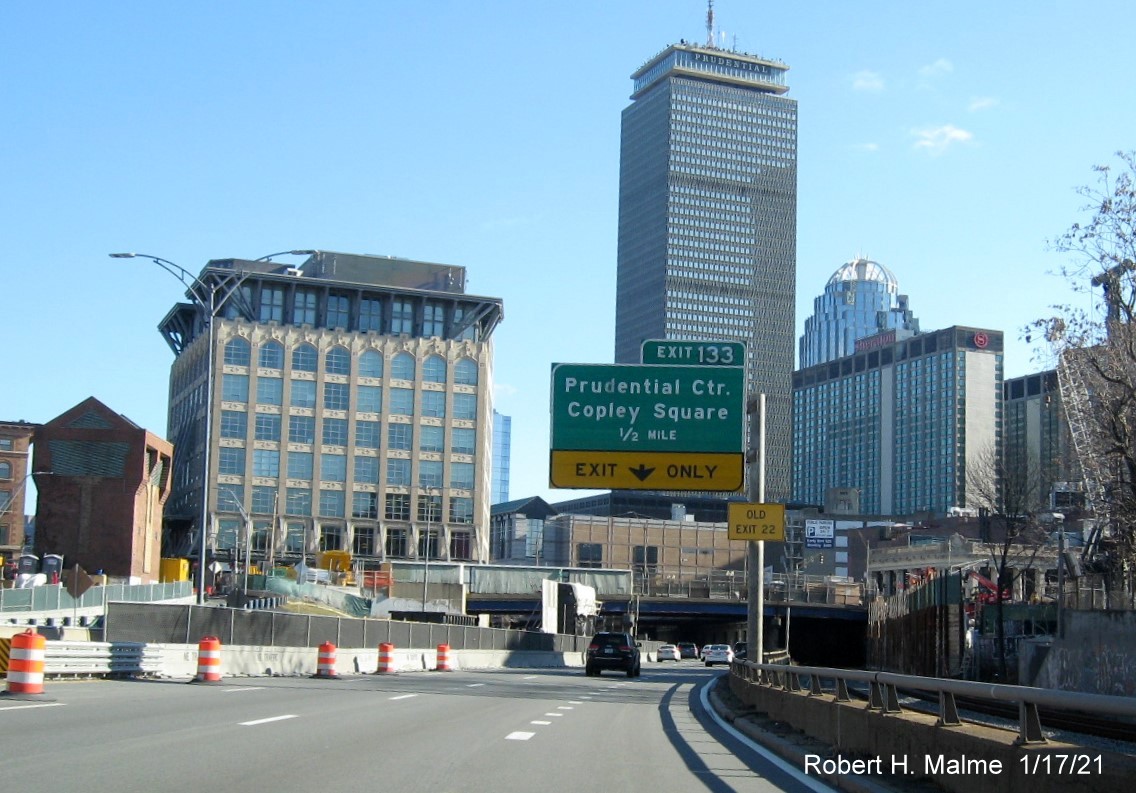 Image of auxiliary sign for Prudential Center exit with new milepost based exit number and yellow Old Exit 22 sign on support post on I-90 East in Boston, January 2021