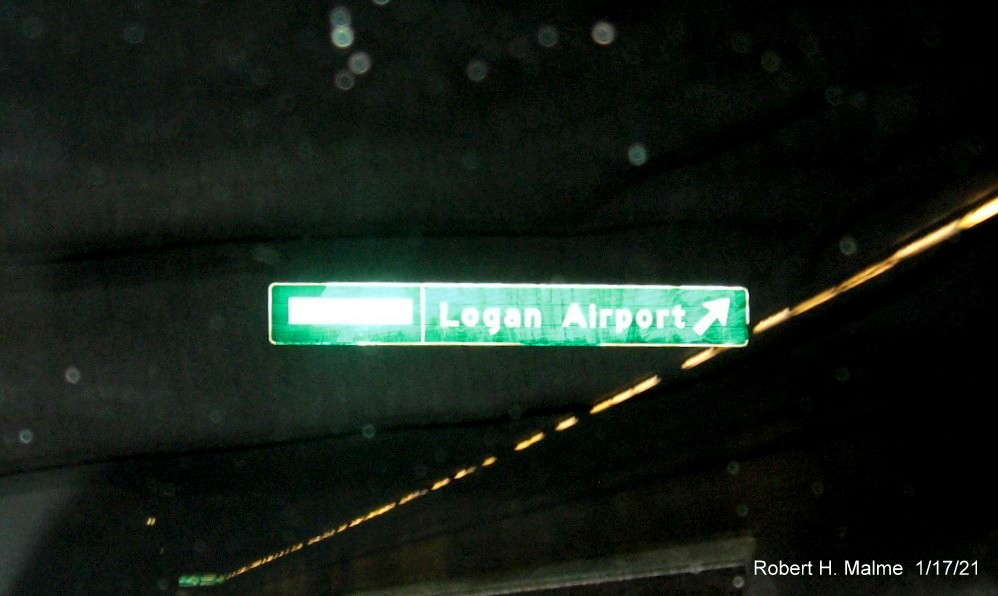 Image of overhead ramp sign connected to ceiling of the Ted Williams Tunnel with new milepost based exit number, to reflective to see in image, on I-90 East/Massachusetts Turnpike in East Boston, January 2021
