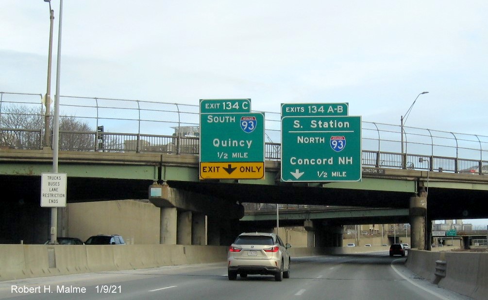 Image of 1/4 Mile Advance overhead signs for I-93 and South Station exits with new milepost based exit numbers on I-90/Mass Pike East in Boston, January 2021