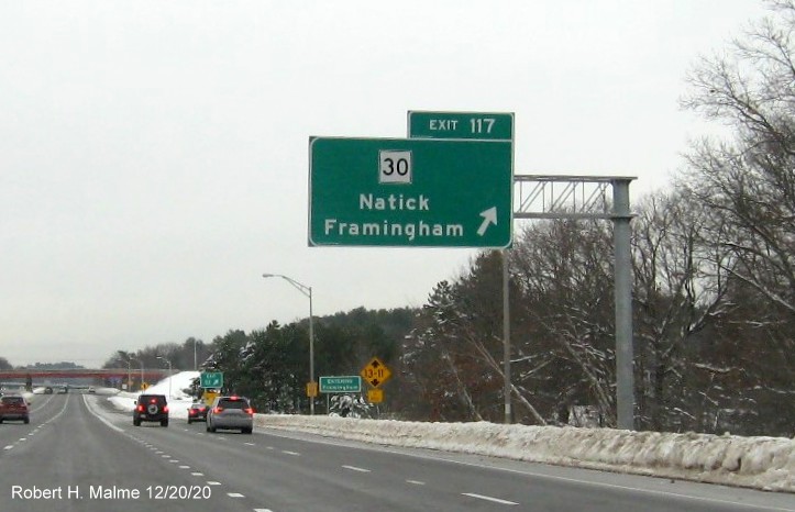 Image of overhead sign for MA 30 exit ramp with new milepost based exit number and gore sign beyond with new number and yellow old exit number tab below on I-90/Mass Pike West in Natick, December 2020
