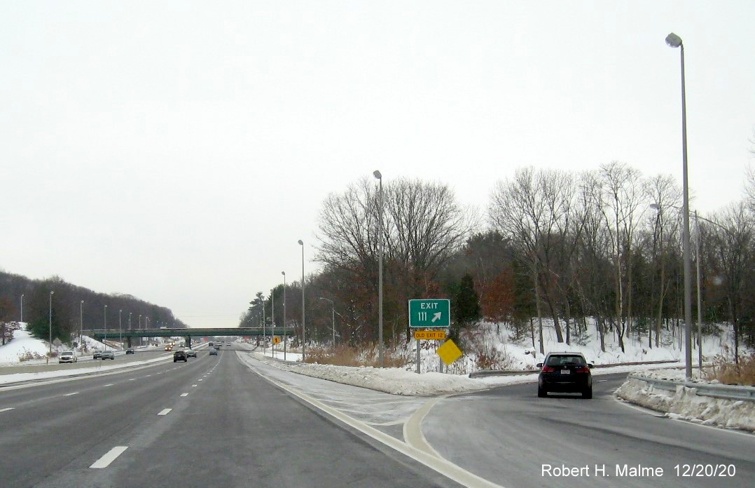 Image of gore sign for MA 9 exit with new milepost based exit number and yellow old exit number tab below on I-90/Mass Pike West in Framingham, December 2020