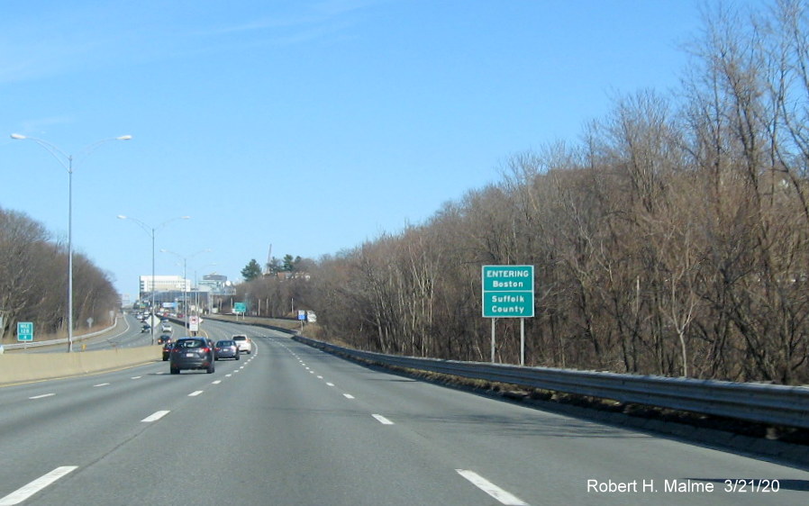 Image of guide sign marking the border with Boston/Suffolk County on I-90 East in Newton
