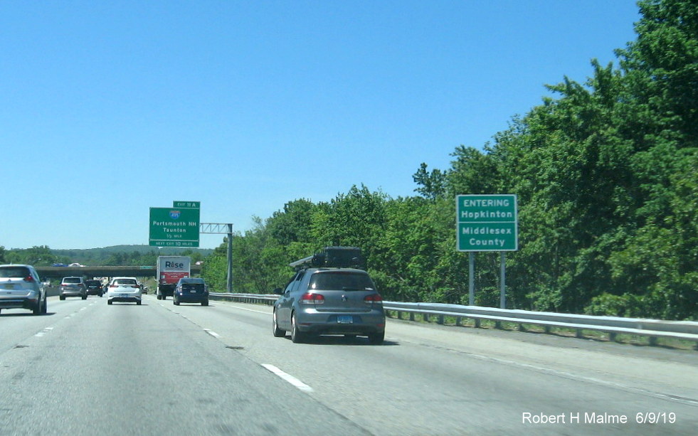 Image of a two jurisdicational boundary sign for entering Middlesex County and entering Hopkinton on I-90/Mass Pike West