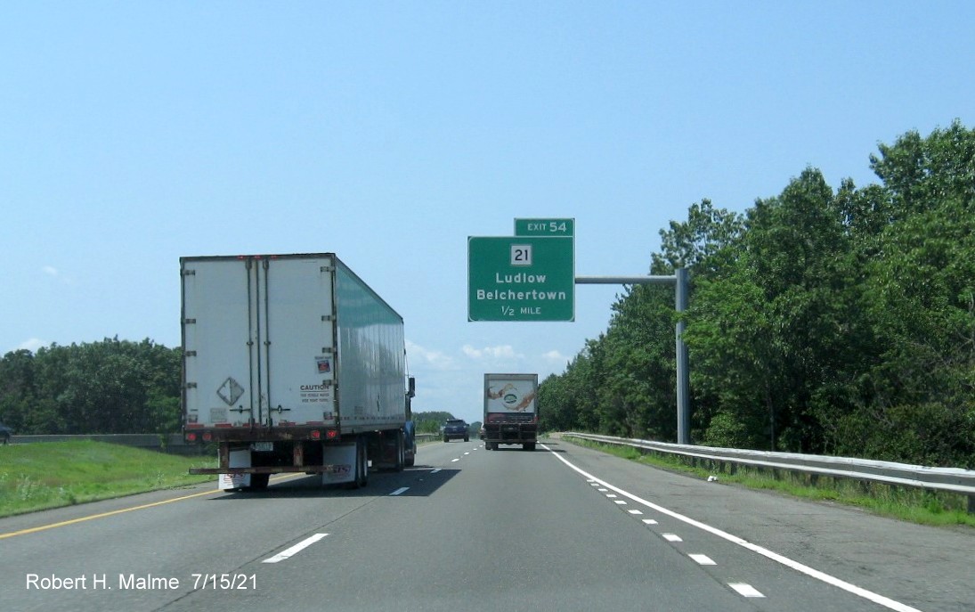 Image of 1/2 mile advance overhead sign for MA 21 exit with new milepost based exit number on I-90/Mass Pike West in Ludlow, July 2021