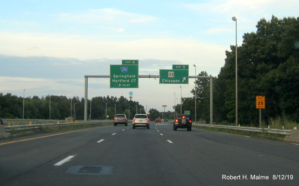 Image of overhead exit and 2-mile advance signs at ramp to MA 33 exit on I-90/Mass Pike East in Chicopee in Aug. 2019