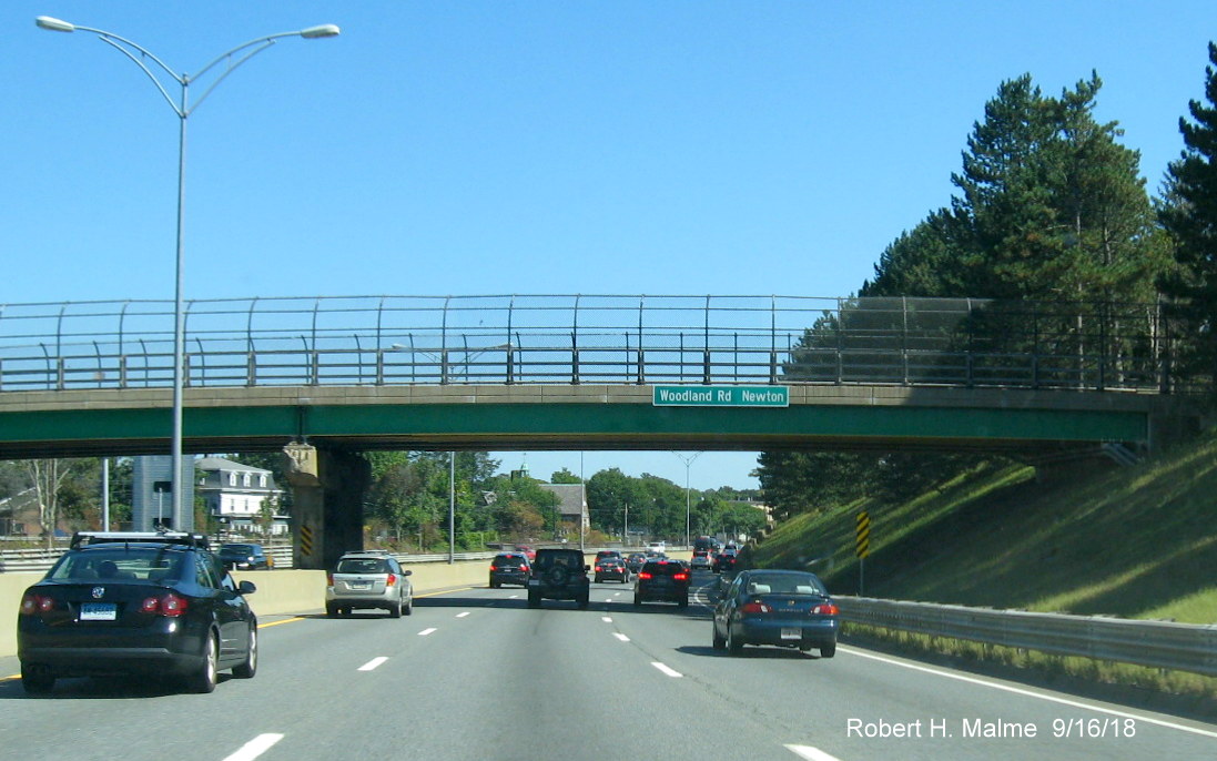 Image of recently placed street and city name sign on bridge over I-90/Mass Pike East in Newton