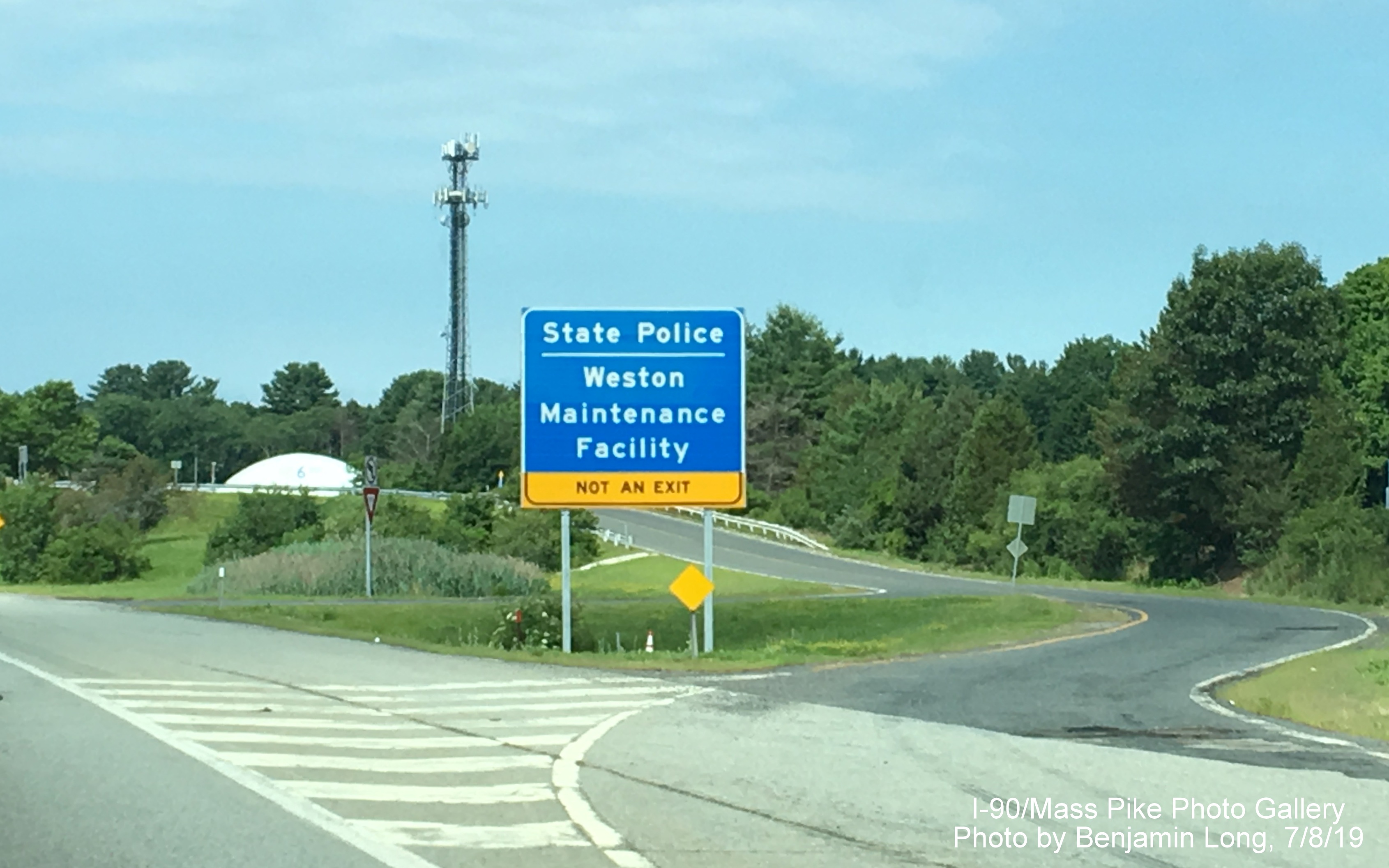 Image of newly placed blue advisory sign for entrance to Weston State Police Barracks/Maintenance
                                                   Facility on I-90/Mass Pike West, by Benjamin Long