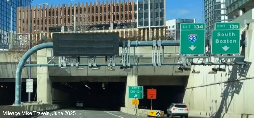 Image of the overhead signage at the I-93/South Boston exits which still includes an 
		Old Exit number tab on the gore sign, January 2021