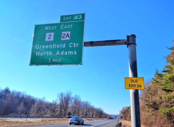 Image of 1 mile advance overhead sign for MA 2 West/MA 2A East exits with new milepost based exit number and yellow Old Exit 26 sign attached below, by Greenfield Record, March 2021