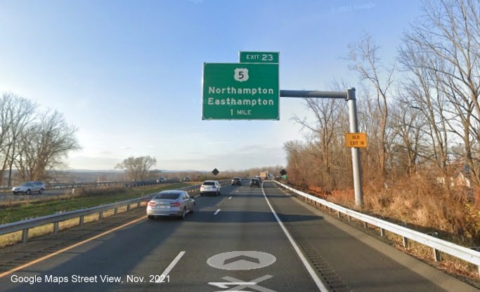 Image of 1 mile advance overhead sign for US 5 exit with new milepost based exit number and yellow Old Exit 18 sign on support on I-91 North in Northampton, Google Maps Street View image, November 2021
