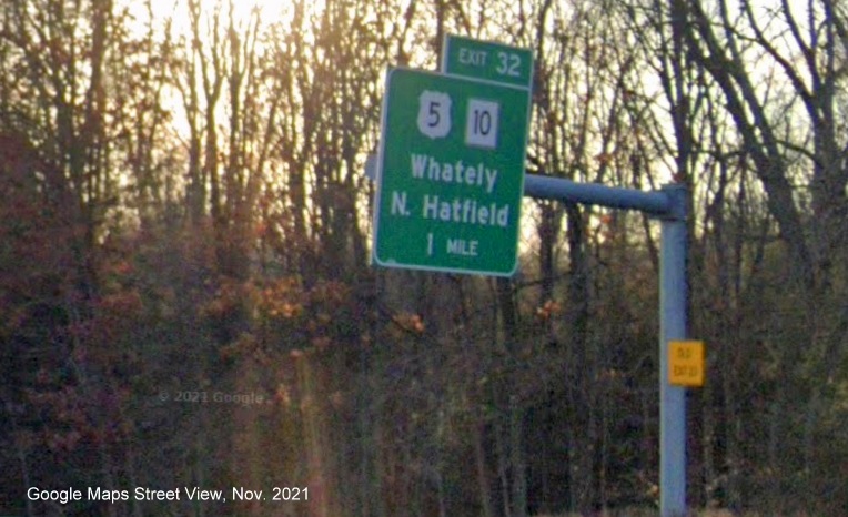 Image of 1 Mile advance sign for US 5/MA 10 exit with new milepost based exit number and yellow Old Exit 23 advisory sign on support on I-91 South in Whately, Google Maps Street View image, November 2021