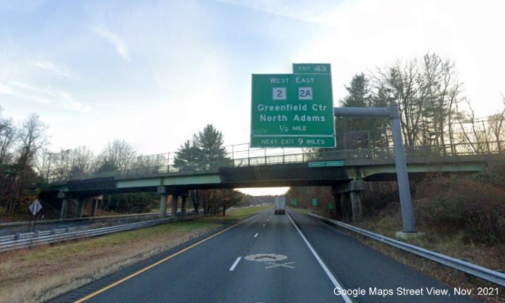 Image of 1/2 mile advance overhead sign for MA 2 West/MA 2A East exit with new milepost based exit number on I-91 South in Greenfield, Google Maps Street View image, November 2021