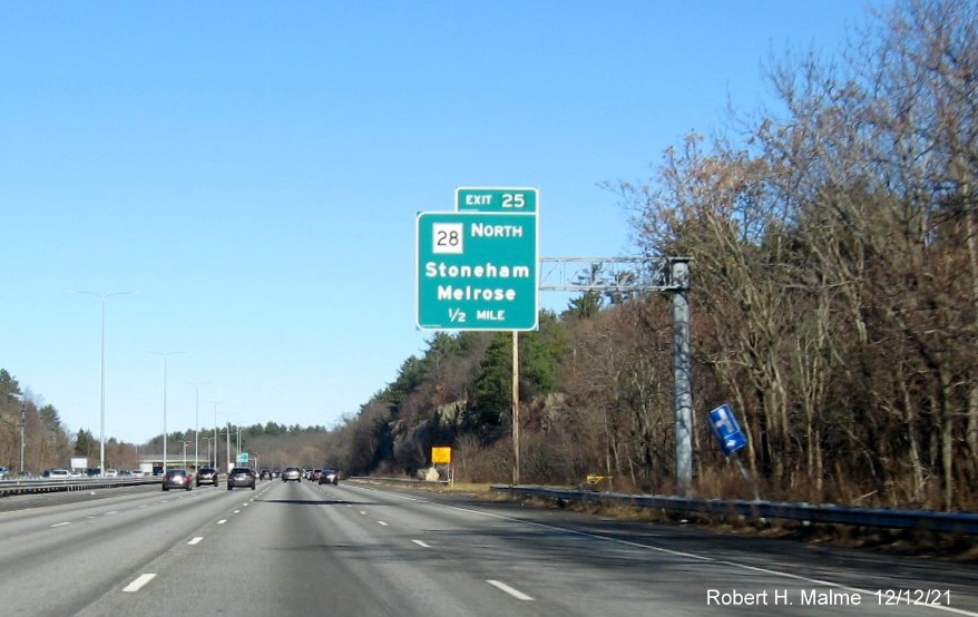 Image of 1/2 mile advance overhead sign for MA 28 Stoneham exit with new milepost based exit number on 
                                          I-93 North in Stoneham, December 2021