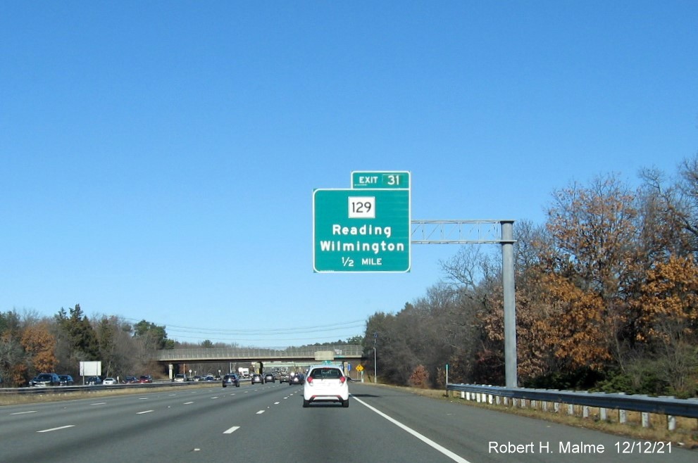 Image of 1/2 mile advance overhead sign for MA 129 exit with new milepost based exit number on I-93 North in Reading, December 2021