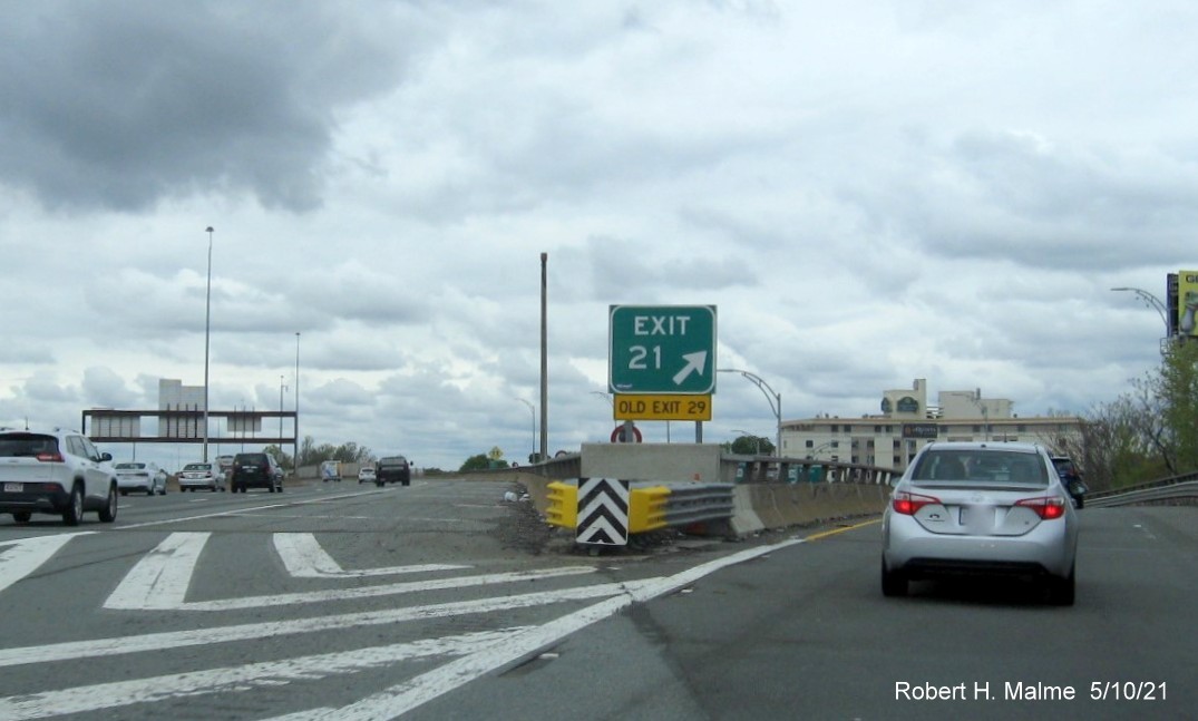 Image of gore sign for MA 28/38 exit with new milepost based exit number and yellow Old Exit 29 sign attached below on I-93 North in Somerville, May 2021