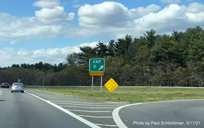 Image of gore sign for MA 129 exit with new milepost based exit number and yellow
                                           Old Exit 38 sign attached below on I-93 North in Wilmington, by Paul Schlichtman, May 2021