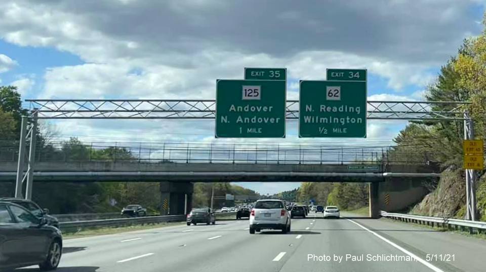 Image of overhead advance signage for MA 125 and MA 62 exits with new milepost based exit number and yellow
                                           Old Exit 40 and 41 advisory signs on right support on I-93 North in Wilmington, by Paul Schlichtman, May 2021