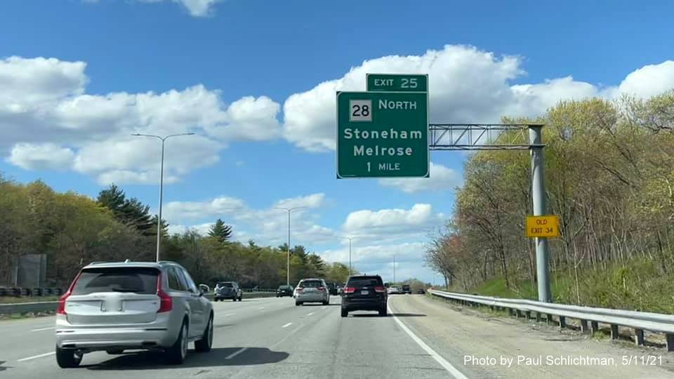 Image of 1 mile advance overhead sign for MA 28 North exit with new milepost based exit number and yellow Old Exit 34 advisory sign on support on I-93 North in Medford, by Paul Schlichtman, May 2021