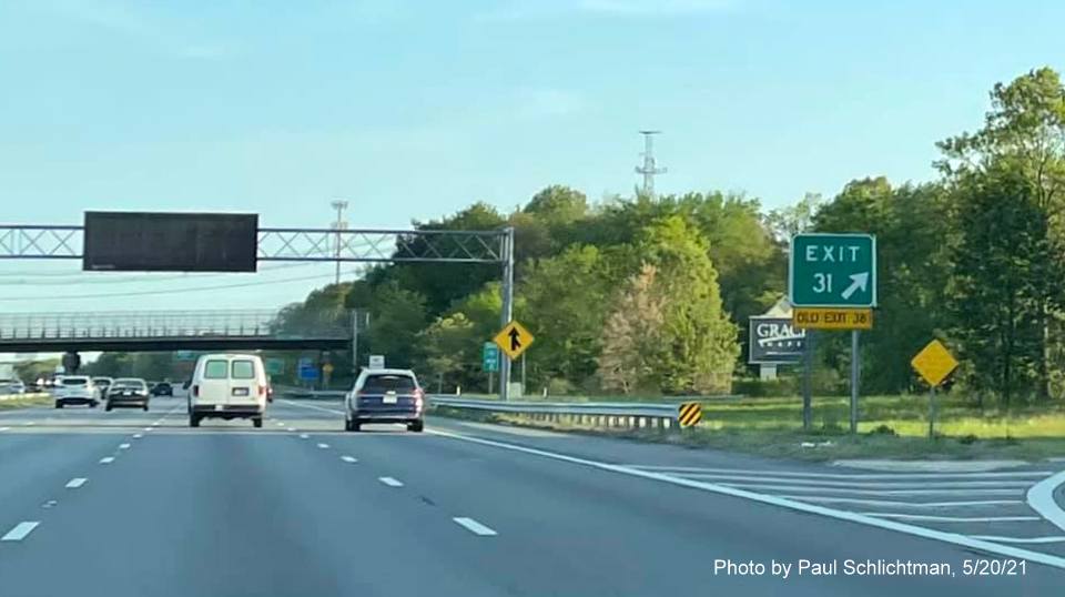 Image of gore sign for MA 129 exit with new milepost based exit number and yellow Old Exit 38 sign attached below 
                  on I-93 North in Wilmington, by Paul Schlichtman, May 2021