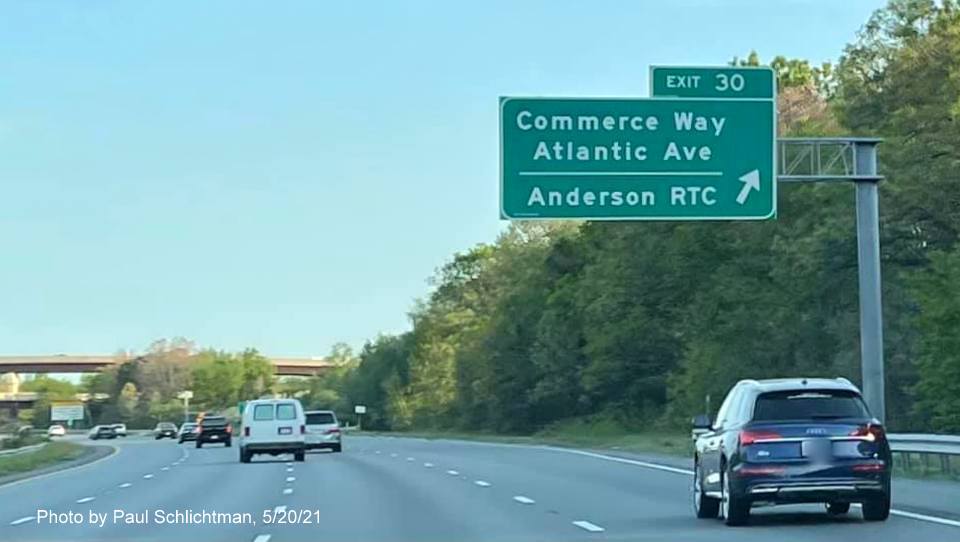 Image of overhead ramp sign for Commerce Way exit with new milepost based exit 
                                            number on I-93 South in Woburn, by Paul Schlichtman, May 2021