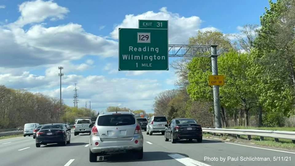 Image of 1 mile advance overhead sign for MA 129 exit with new milepost based exit number and yellow
                                           Old Exit 38 advisory sign on support on I-93 North in Wilmington, by Paul Schlichtman, May 2021
