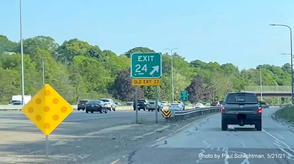 Image of gore sign for MA 28 Fellsway West exit with new milepost based exit number and yellow Old Exit 33 
                                            sign attached below on I-93 South in Medford, May 2021