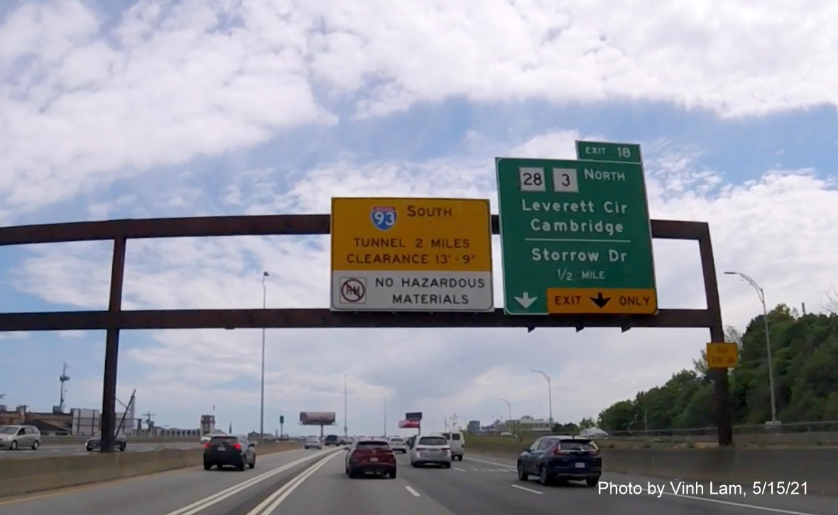 Image of 1/2 mile advance sign for MA 28/MA 3/Storrow Drive exit with new milepost based exit number and yellow Old Exit 26 advisory sign on left support on I-93 South in Somerville, by Vinh Lam, May 2021