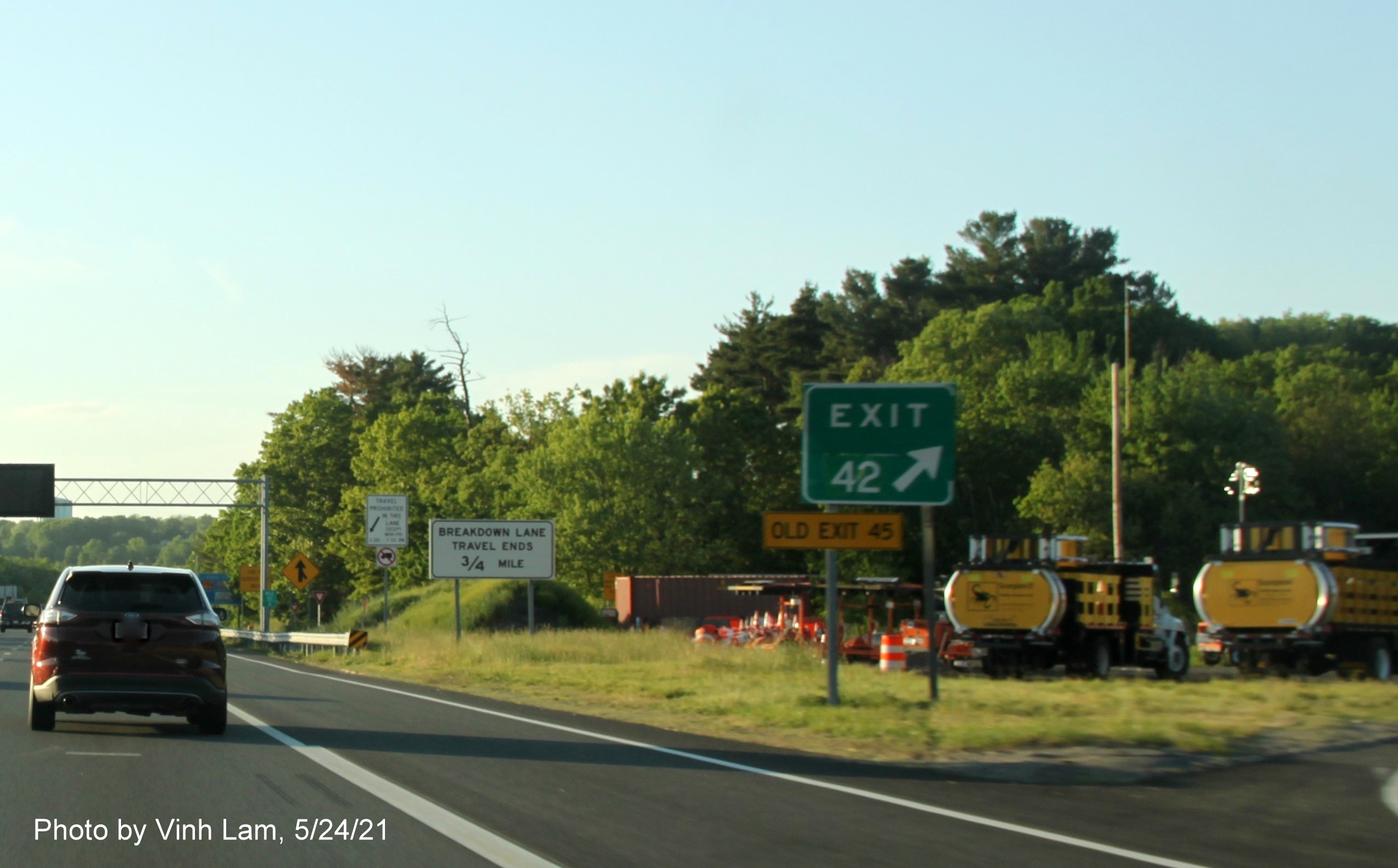 Image of gore sign for River Road exit with new milepost based exit number and yellow Old Exit 45 sign attached below on I-93 North in Andover, by Vinh Lam, May 2021
