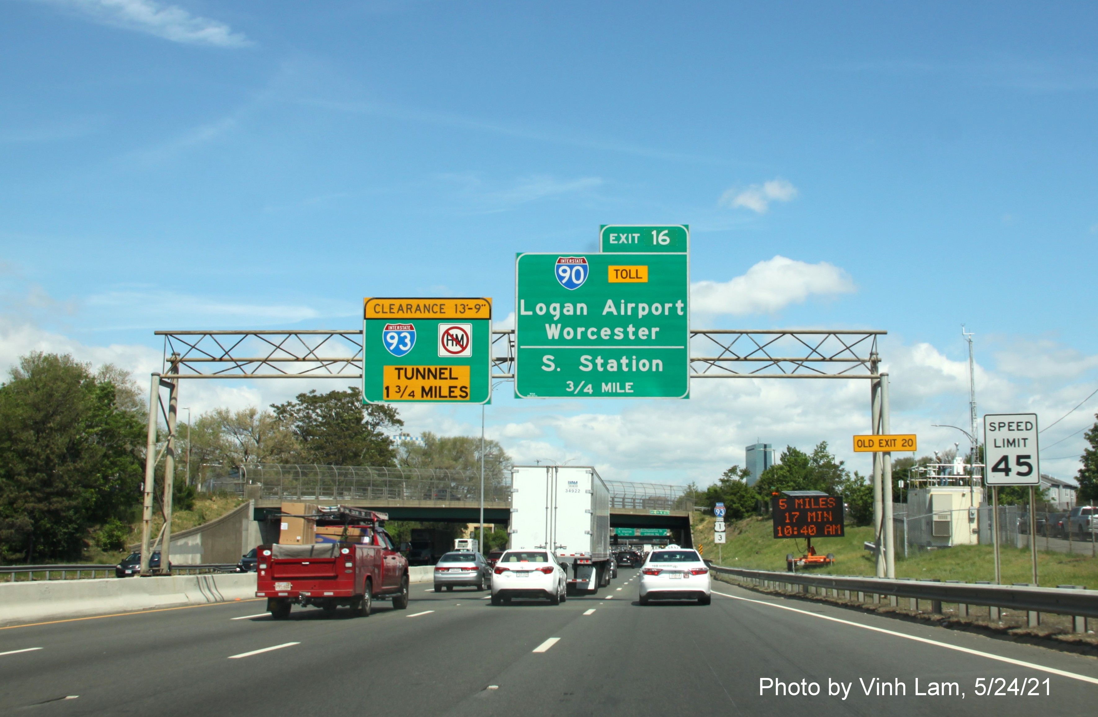 Image of 3/4 mile advance sign for I-90/South Station exit with new milepost based exit number and yellow Old Exit 20 advisory sign on right support on I-93 North in Dorchester, by Vinh Lam, May 2021