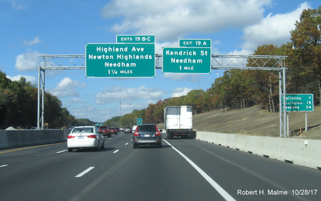 Image of revised advance overhead exit signs for Kendrick St and Highland Ave on I-95 North in Needham