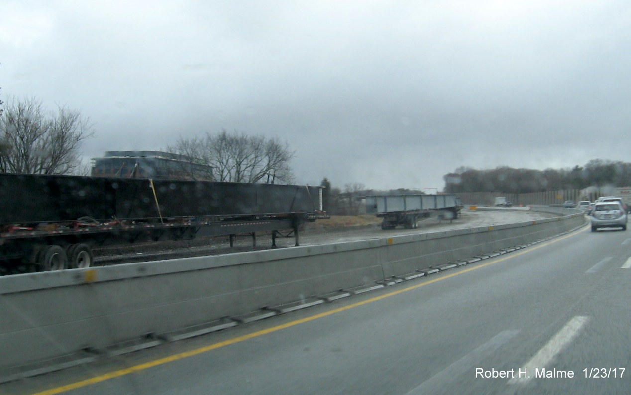 Image of metal beams for future bridge being stored along median by I-95 South in Needham