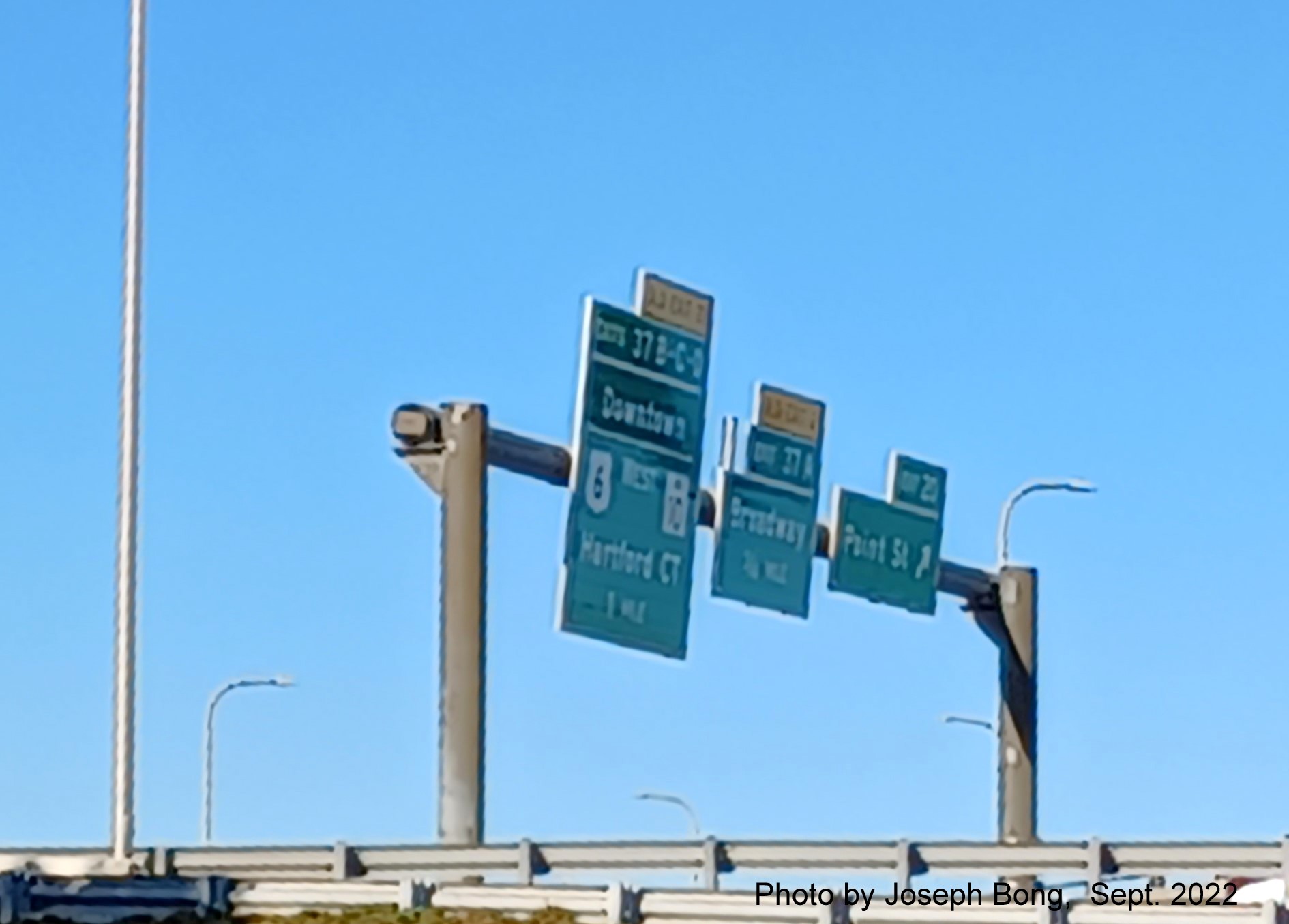 Image of overhead signs for US 6 West/RI 10 exits with new milepost based exit numbers,
                                         by Joseph Bong, September 2022