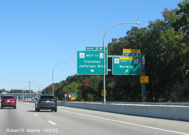 Image of overhead ramp sign for RI 37 exits with new milepost based exit numbers and yellow Old Exits 15 A-B sign on gantry arm on I-95 North in Warwick, October 2022