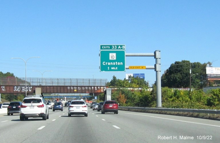 Image of 1 mile advance overhead sign for RI 10 exit with new milepost based exit number and yellow Old Exit 16 sign on gantry arm on I-95 North in Cranston, October 2022