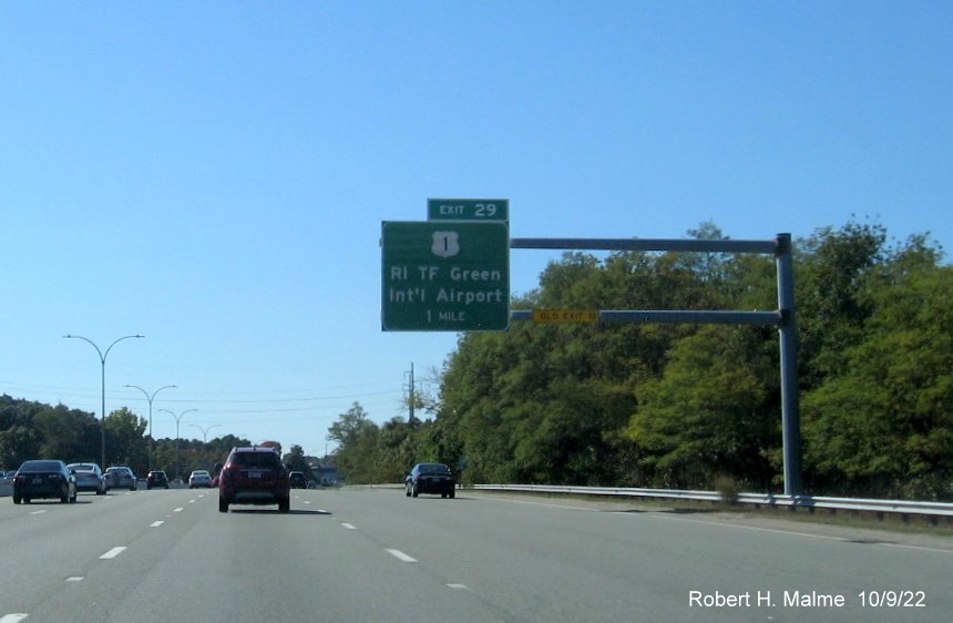 Image of 1 mile advance overhead sign for US 1/T.F. Green Airport Connector exit with new milepost based exit number and yellow Old Exit 13 sign on gantry arm on I-95 South in Warwick, October 2022