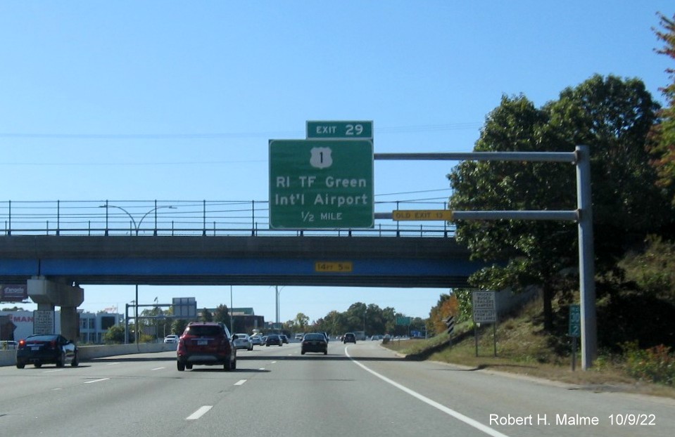 Image of 1/2 mile advance overhead sign for US 1/T.F. Green Airport Connector exit with new milepost based exit number and yellow Old Exit 13 sign on gantry arm on I-95 South in Warwick, October 2022